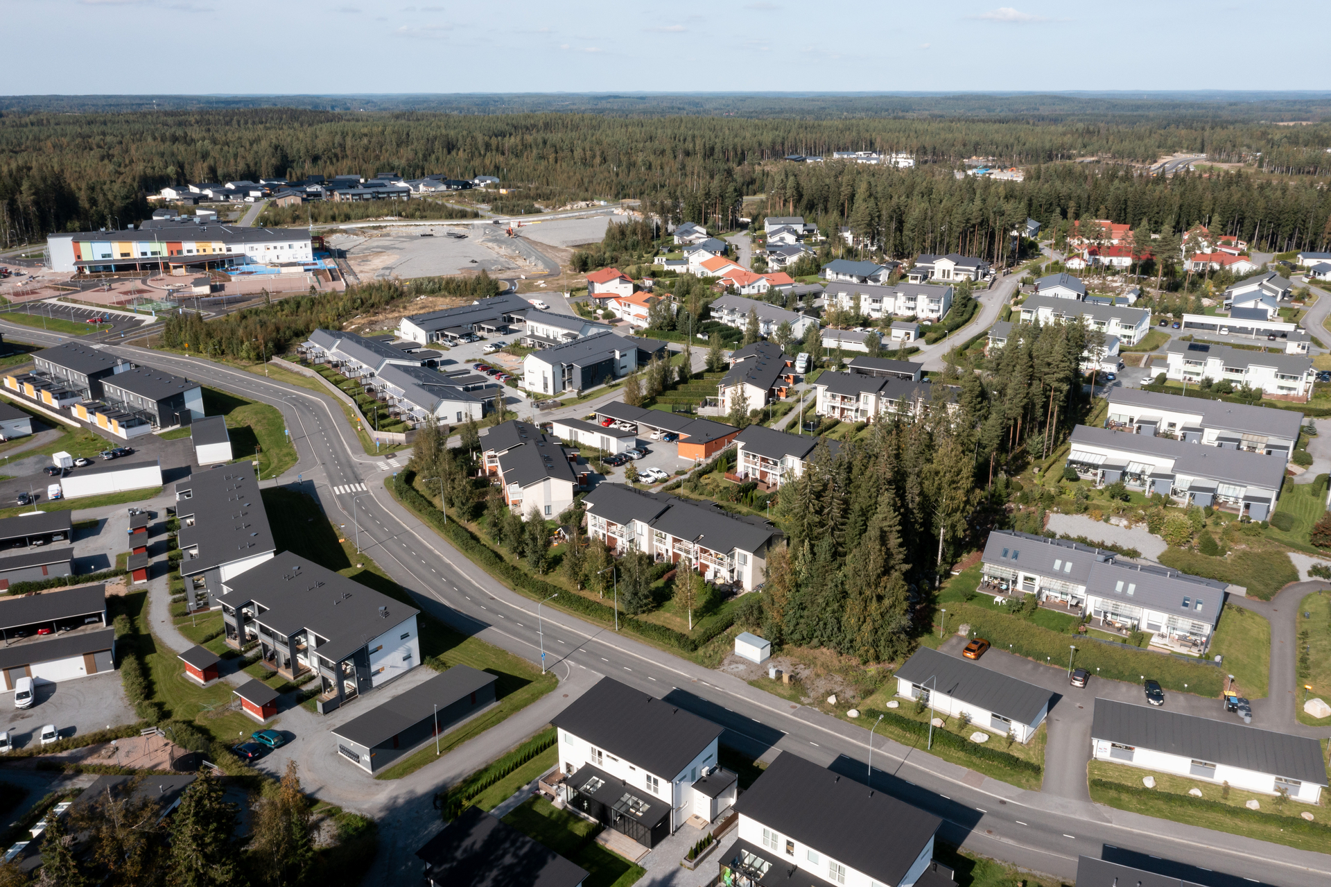 Ilmakuva, jossa näkyy rivitaloja ja koulurakennus.