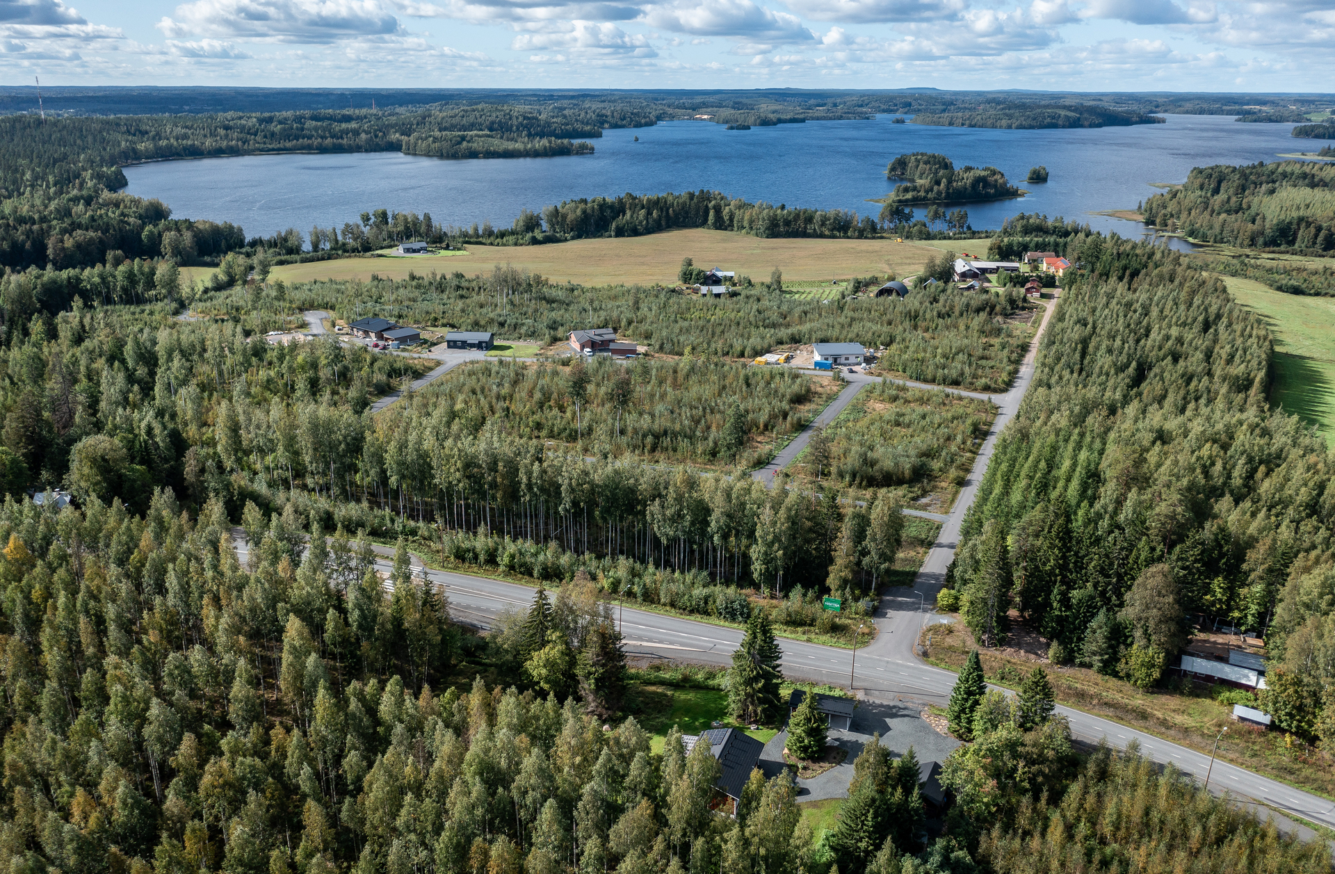 Ilmakuva uudesta omakotitaloalueesta maaseutu- ja järvimaiseimassa.