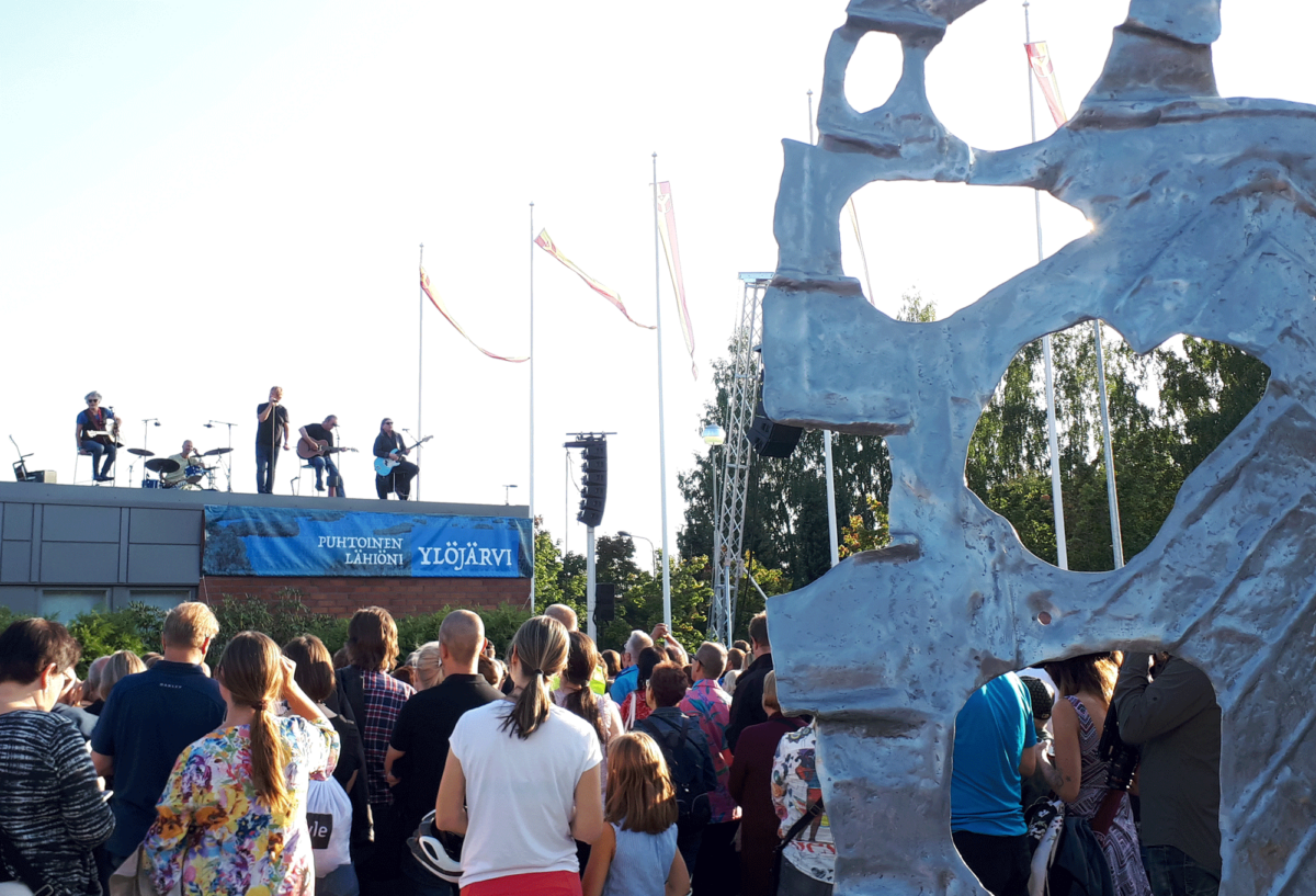 Ulkoilmakonsertti, jossa yhtye soittaa rakennuksen katolla.