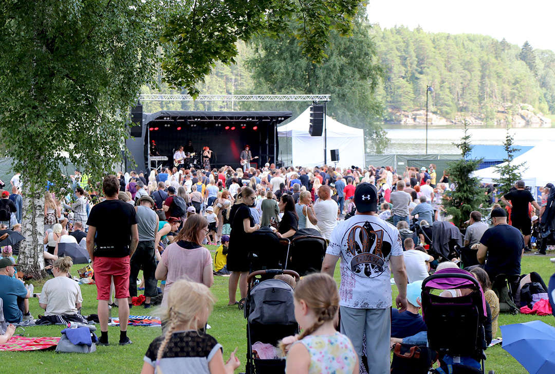 Ihmisiä kesäfestivaaleilla järven rannassa.